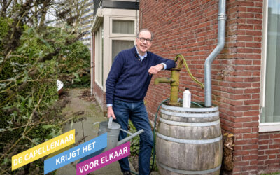 Lex Welter staat naast zijn regenton om regenwater op te vangen