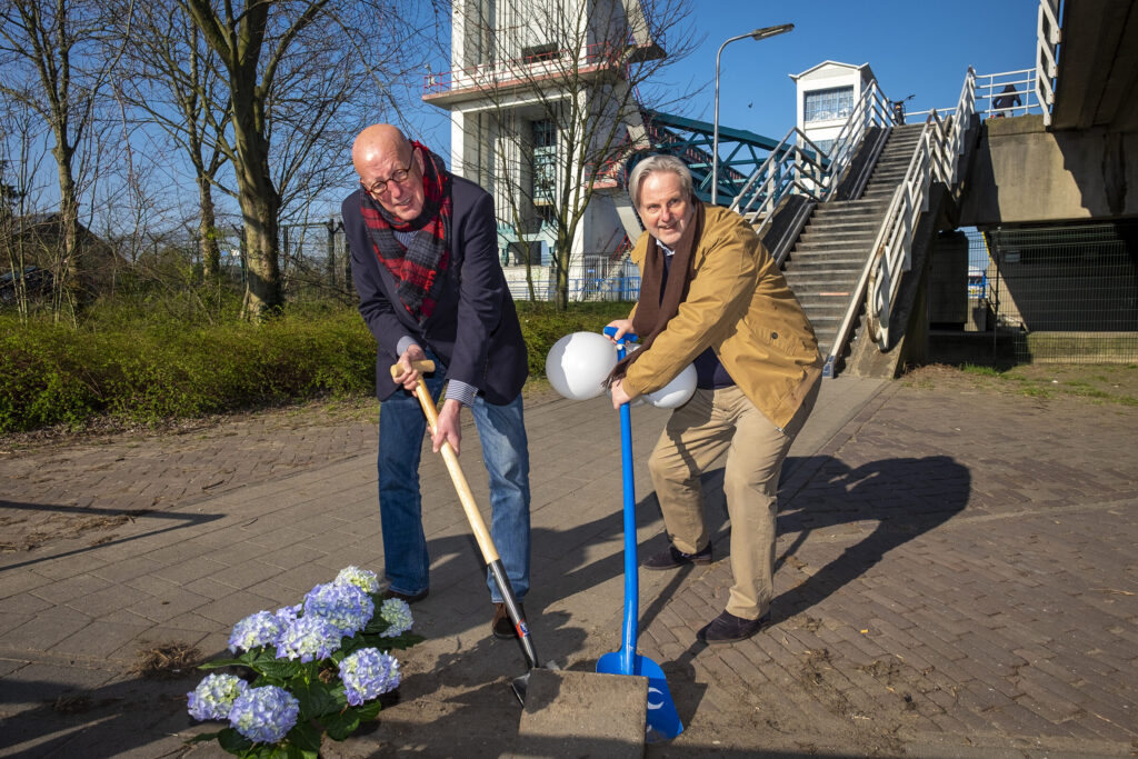 Wethouder Nico van Veen en Coen Derickx scheppen samen een tegel uit de grond