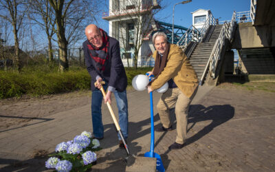 Wethouder Nico van Veen en Coen Derickx scheppen samen een tegel uit de grond