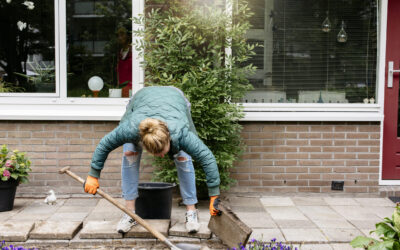 Bewoner haalt tegels uit de tuin om te vervangen met planten en bloemen.