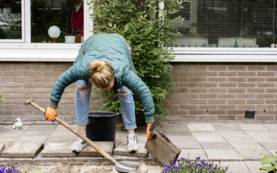 Bewoner haalt tegels uit de tuin om te vervangen met planten en bloemen.
