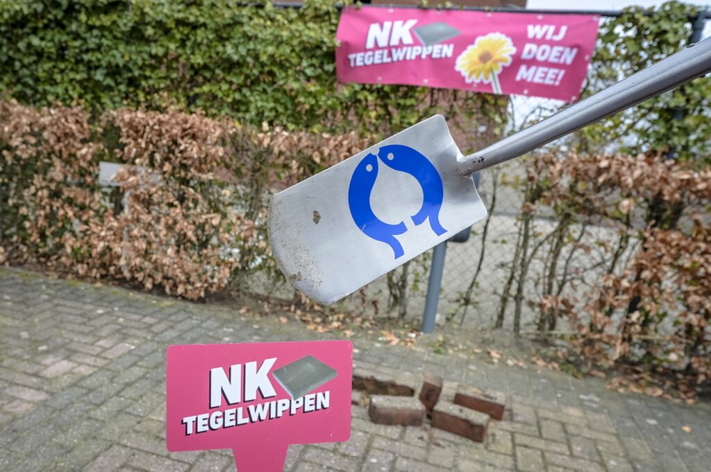 Tegels eruit op parkeerplaats door schep met Capelse vissen erop