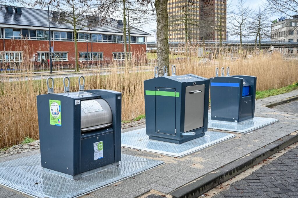 Ondergrondse container voor restafval, gft en papier op een rij, voor het gescheiden inleveren van afvalsoorten.