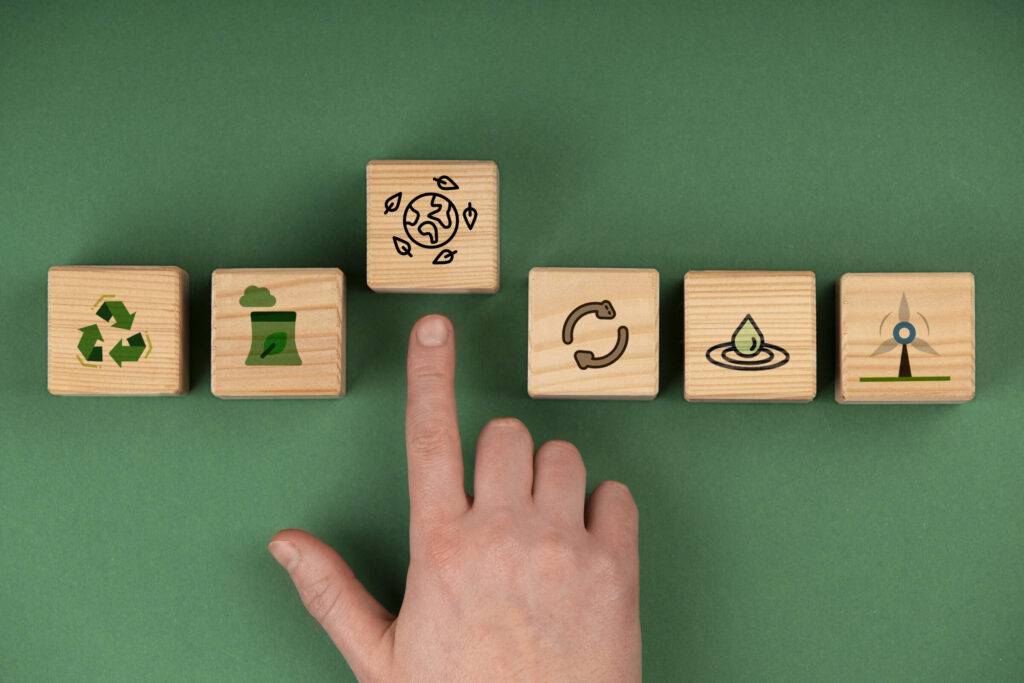 Hand die wijst naar duurzame doelen zoals recycling, duurzame energie en het hergebruik van materialen