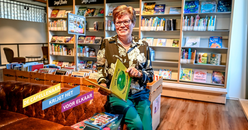 Ingrid Buijs zit op de bank in de bibliotheek met boeken om haar heen en ze heeft er een vast