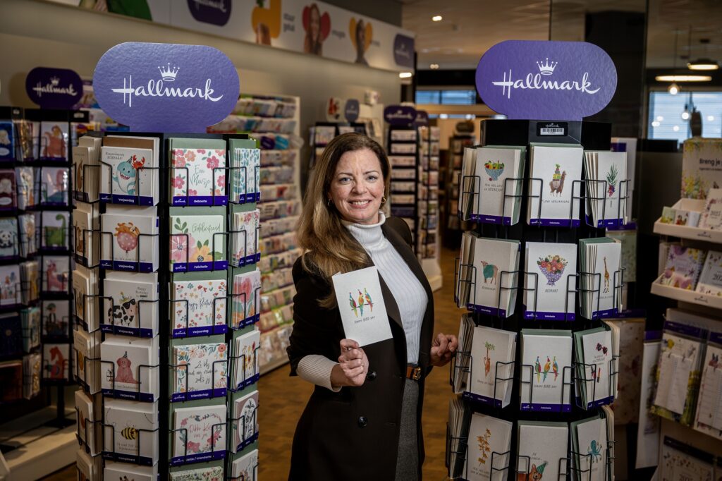 Tamara van Loo tussen twee kaartenmolens, met een kaart in de hand