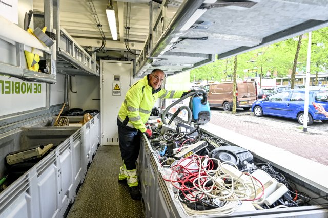 Een medewerker van de Milieukraam neemt spullen in.