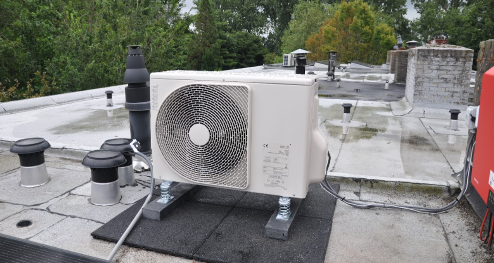 Buitenunit van een warmtepomp op het dak.