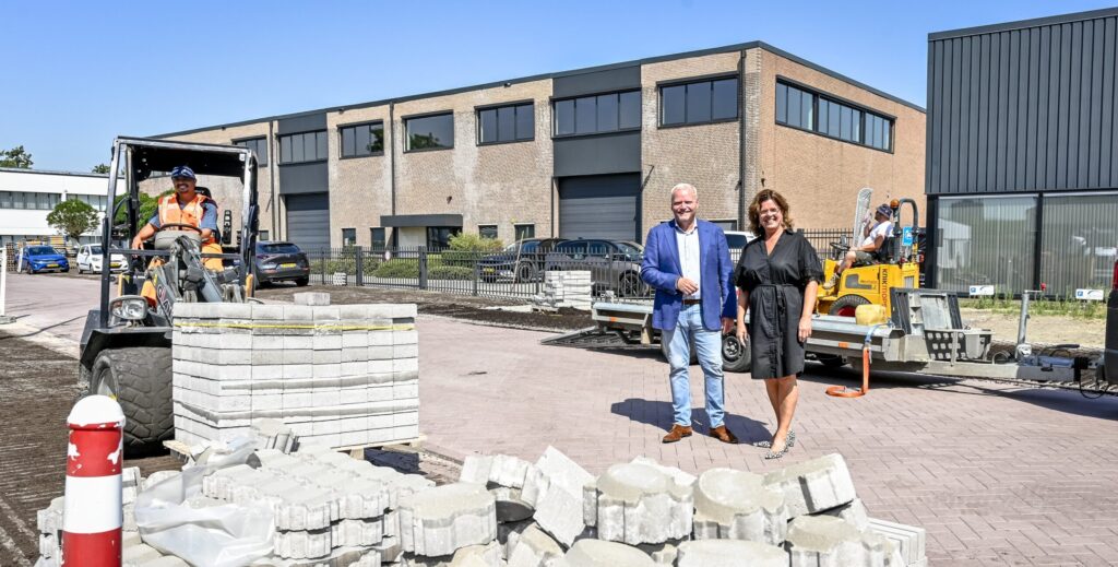 Wethouder Eric Faassen en ondernemer Monique Maurik staan achter een stapel stenen in Capelle-West.