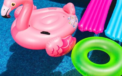 Opblaasluchtbedden, zwemband en opblaad flamingo in het zwembadwater