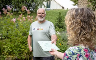 Tuinranger geeft map met informatie aan een bewoner