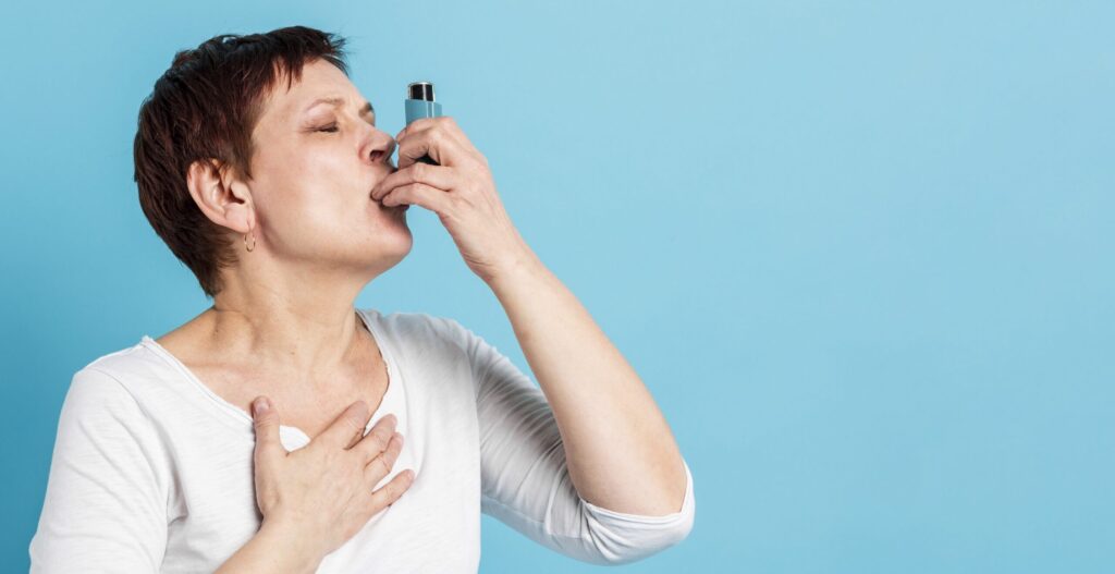 Vrouw met astma gebruikt een puffertje.