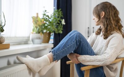 Vrouw zit met haar voeten op de verwarming.