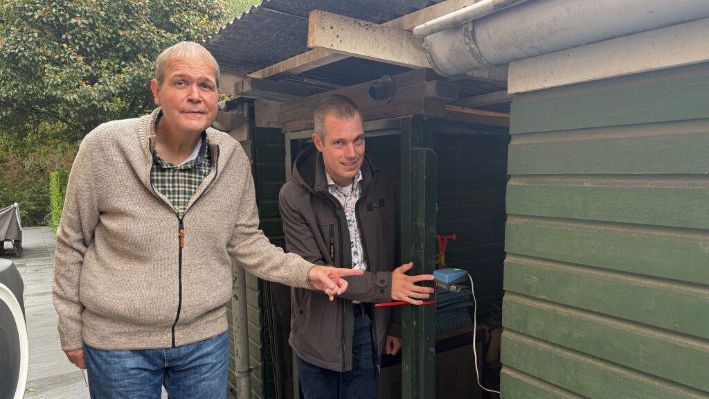 Ton Hoppener toont wethouder Sjoerd Geissler de sensor in zijn achtertuin in Schollevaar.