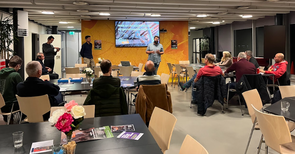 Zaal vol mensen en iemand die een presentatie geeft.