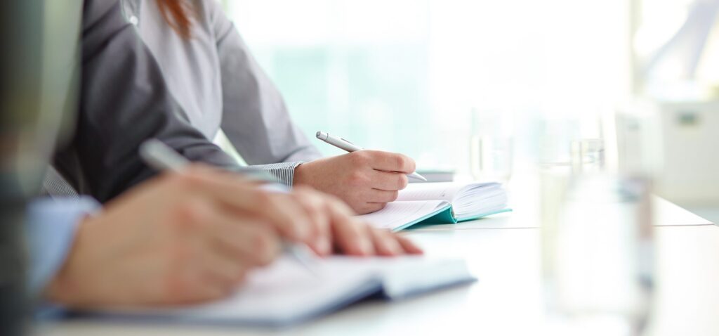 Vergadering, schrijvende handen