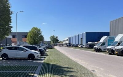 Straat op een industrieterrein met groene, waterdoorlatende parkeerplekken.