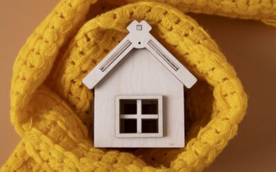 Houten speelgoedhuisje met een sjaal eromheen, om aan te tonen wat isolatie doet voor uw huis.