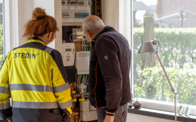 Een monteur van Stedin kijkt met een bewoner in diens meterkast.