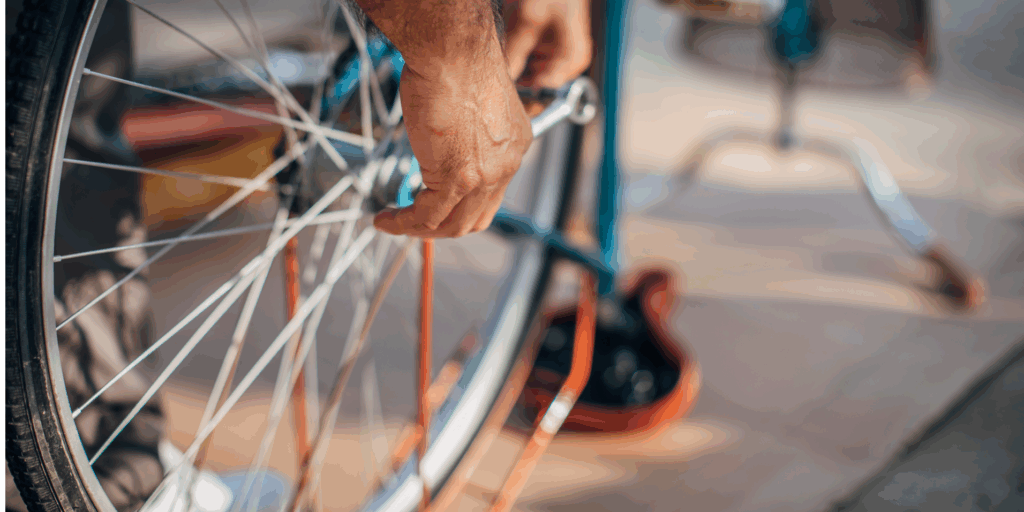Iemand die een wiel van een fiets repareert