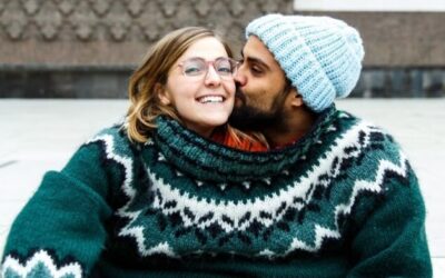 Verliefd stel samen in 1 warme gebreide trui. Hij kust haar.