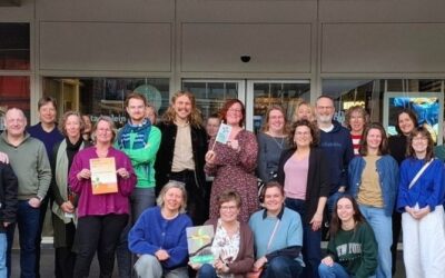 Groepsfoto van mensen die bij de bibliotheek werken, met het certificaat.