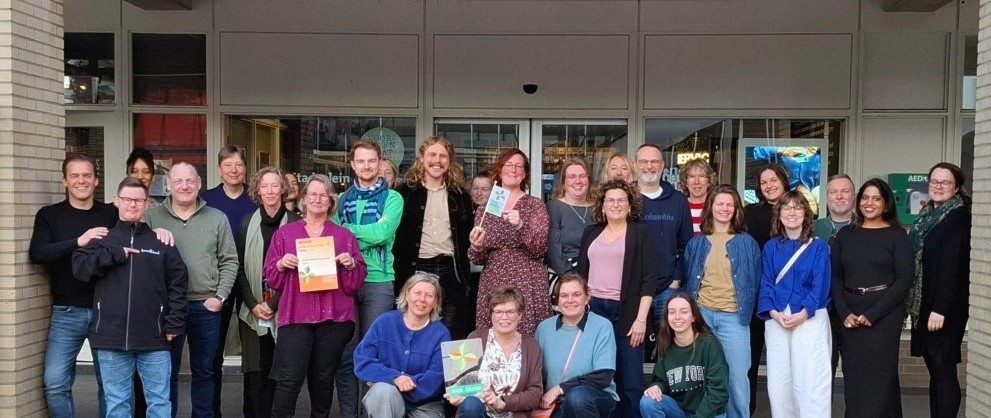 Groepsfoto van mensen die bij de bibliotheek werken, met het certificaat.