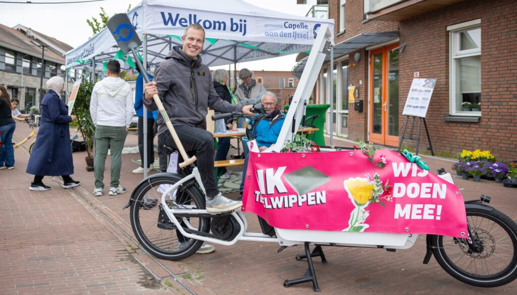 Wethouder Sjoerd Geissler op een bakfiets met een schep in zijn hand