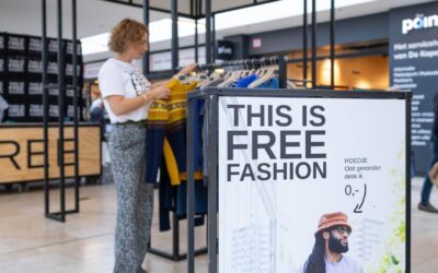 Een vrouw kijkt in de kledingrekken van Free Fashion in de Koperwiek.