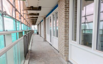 Galerij van flatgebouw in de steigers met nieuwe kunststof kozijnen.