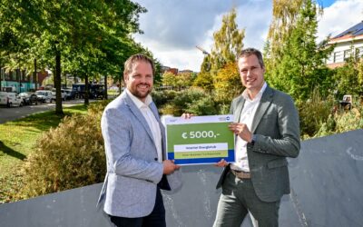 Penningmeester Paul van Dorp (links) neemt de cheque van wethouder Duurzaamheid Sjoerd Geissler in ontvangst.